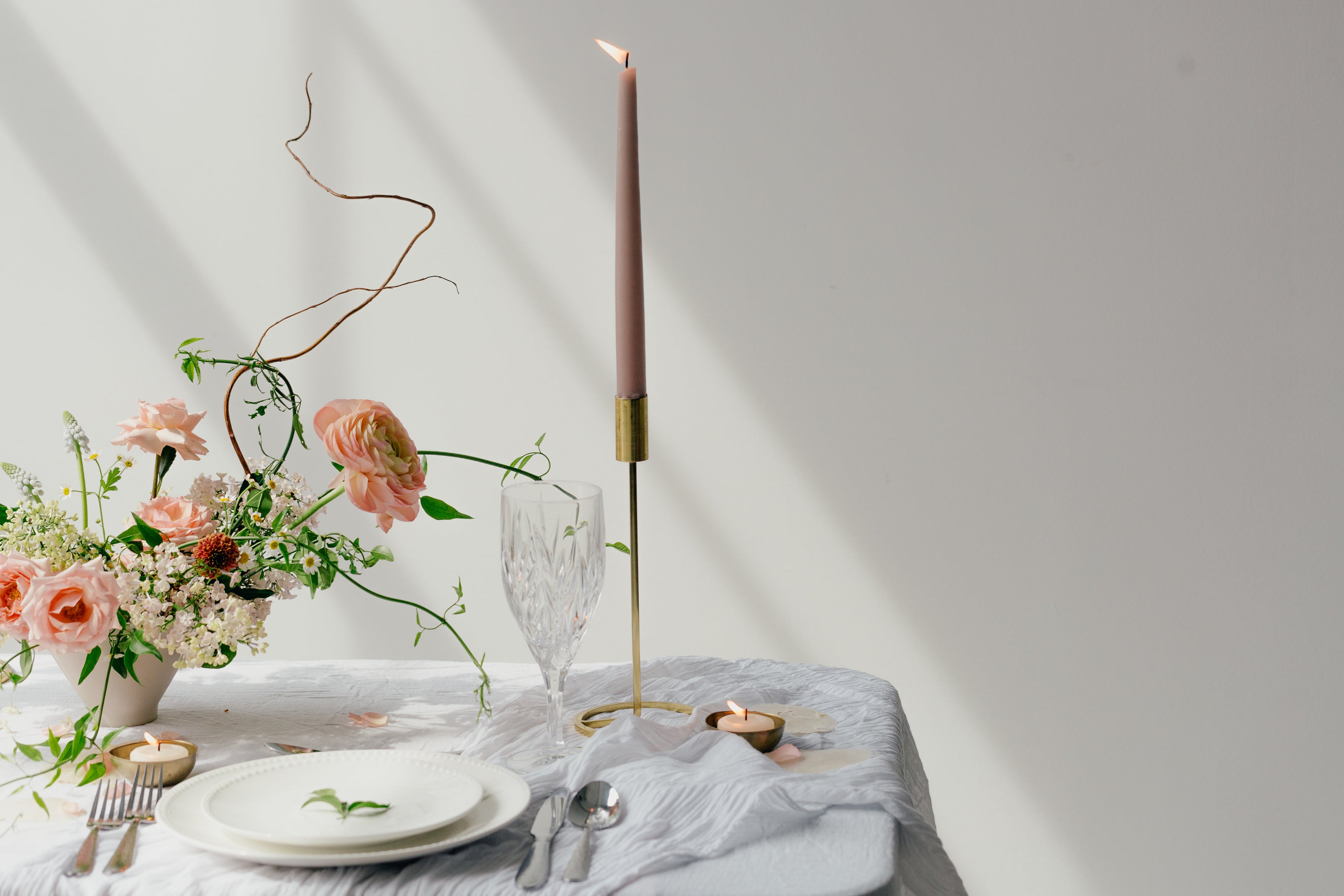 elemento di arredamento olfattivo su tavola apparecchiata ed ornamentata con fiori, cialda profumata e candela su candelabro in ottone, kodo.boutique